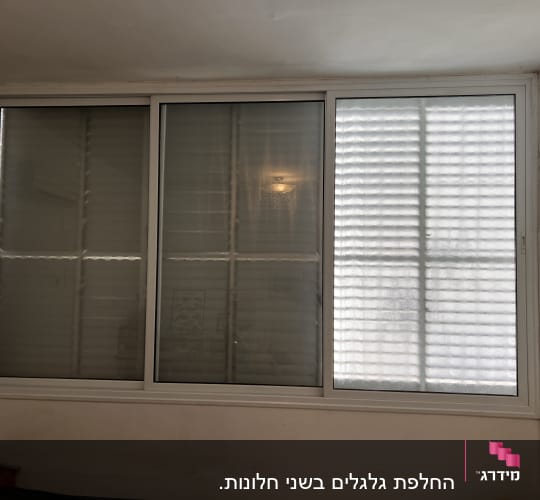 תריסים סגורים על חלון גדול עם מסגרת לבנה